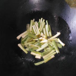 大蒜洗净切段，茎叶分开放。锅里放油烧热，倒入蒜白