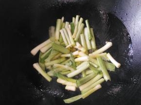 大蒜洗净切段，茎叶分开放。锅里放油烧热，倒入蒜白