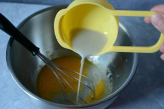 蛋黄，蛋清分离。将10g细砂糖加入牛奶中，手动打蛋器将细砂糖和黑豆浆混合均匀。接着加入玉米油继续手动打蛋器搅打混合均匀。