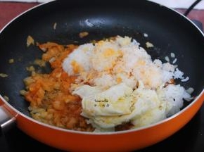 加入蒸好的米饭、煎至八成熟的鸡蛋，放盐、酱油翻炒片刻即可；