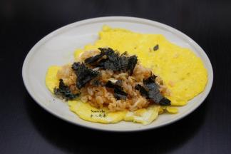 把海苔碾碎加入炒的饭中拌均，放入煎好的鸡蛋中包好，