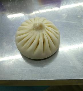 调制面团.将面粉围成窝状,（不喜欢放在桌面上操作的朋友也可以放在盆里操作）将酵母，泡打，糖加入，然后将冷水分次倒入面粉中,用右手调拌面粉,调成