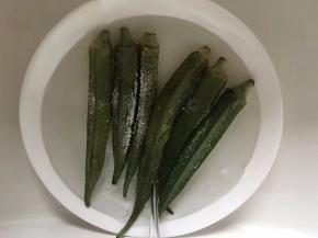 将秋葵放盆里，撒上盐放水，用手搓揉，表面变得光溜溜