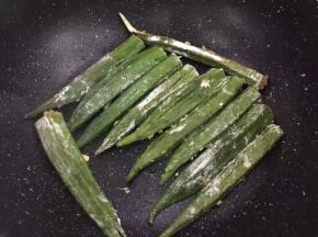 锅里放少许油，油热后将秋葵一个个摆放好，有肉的一面放下面