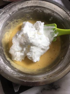 用刮刀将打发好的蛋白的3分之一放到蛋黄糊里，用蛋抽搅拌均匀