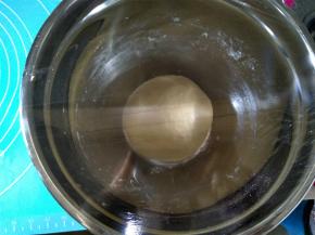 面团表面整理光滑，放回盆内，盖上保鲜膜，放室温处进行第一次发酵