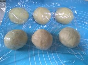 将面团平均分成6份，轻轻滚圆，盖上保鲜膜松弛20分钟