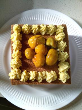 另取一个裱花袋，装上裱花嘴，先在最上边的蛋糕上挤上一圈花型，然后整棵的栗子仁沾上蜂蜜，放在蛋糕中间，边缝可以再挤上几个花。这样栗子可可蛋糕就完成了。