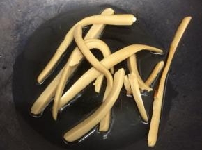 炒锅里加入适量的油烧热后，放入火腿肠煎一下