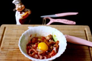 切好的肉丝里、加入打散的鸡蛋、料酒、胡椒粉、鸡精、适量的盐和生抽、5克木薯淀粉搅拌均匀后腌制10分钟