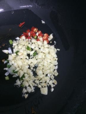 炒锅里加入适量的油，在把蒜、葱和小米椒粒放入锅中，炒出香味