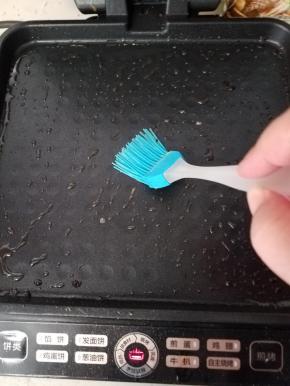 打开电饼铛预热，用一个小刷子在烤盘上刷上一层植物油。