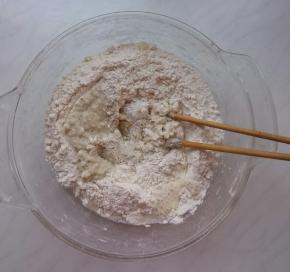 面粉中加入豆渣，再加入滚开的热水，用筷子搅成絮状。