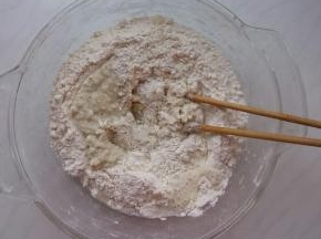 面粉中加入豆渣，再加入滚开的热水，用筷子搅成絮状。