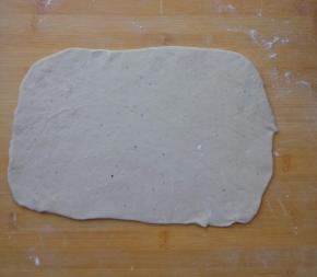 取一个面团，擀成长方形的面片，尽量薄些。不要来回的擀，以中心为圆心，向四周擀薄。