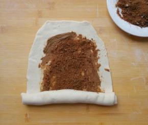 自下向上卷起，边卷边拉长。