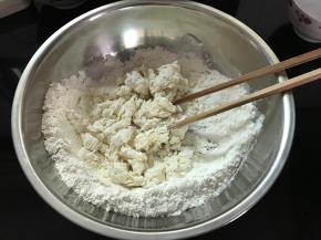 面粉放入盆中，倒入开水，用筷子搅成絮状。