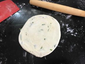 然后再把圆饼按扁擀薄。
