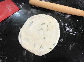 然后再把圆饼按扁擀薄。