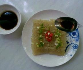 肉皮摆盘，撒上辣椒小葱碎，将调好的酱汁浇在上面。