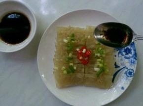 肉皮摆盘，撒上辣椒小葱碎，将调好的酱汁浇在上面。