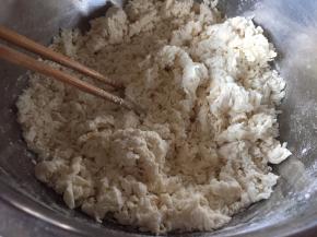 慢慢的加入温水，加入一小勺的盐，用筷子搅拌，成絮状；