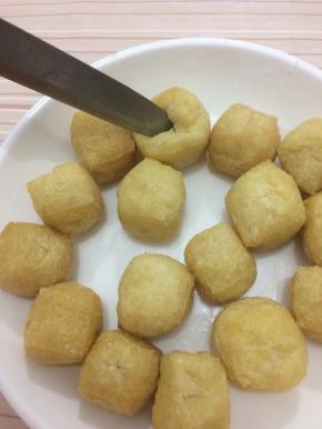 油豆腐用温水洗一下，沥干水分，用刀在中间划成十字刀