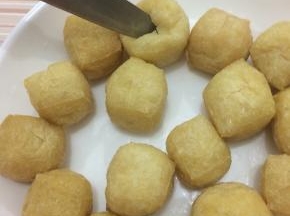 油豆腐用温水洗一下，沥干水分，用刀在中间划成十字刀