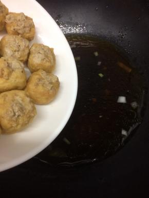 在将酿好的油豆腐放入锅中