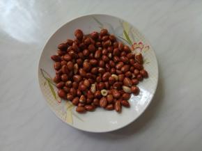 将花生摊平在平盘中晾凉，浇少许白酒，拌匀(使花生更脆)。