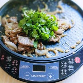 关火加入切好的香菜，继续翻炒，借助电饼铛的余温将香菜炒熟。