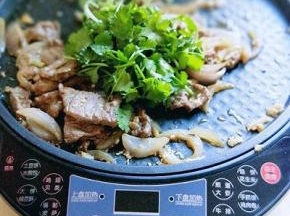 关火加入切好的香菜，继续翻炒，借助电饼铛的余温将香菜炒熟。