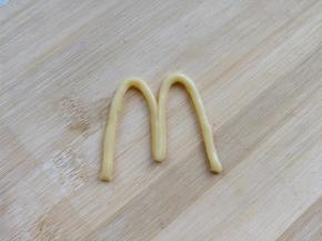 另取一小块原色面团，搓成细条，围成标识的形状