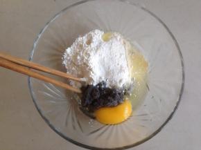 碗里装入玉米油、鸡蛋、面粉和黑豆豆渣