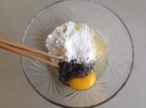 碗里装入玉米油、鸡蛋、面粉和黑豆豆渣