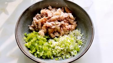 五花肉不太烫手后，取出切碎，青辣椒切碎，葱末混合。