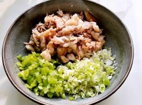 五花肉不太烫手后，取出切碎，青辣椒切碎，葱末混合。
