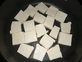 热锅里放入适量植物油，将豆腐放入锅里煎制。