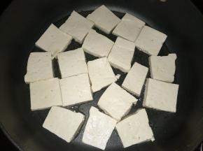 热锅里放入适量植物油，将豆腐放入锅里煎制。