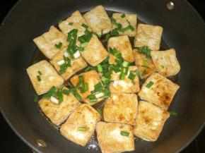 另一面也煎成金黄后放入葱花、生抽、蚝油和适量开火。