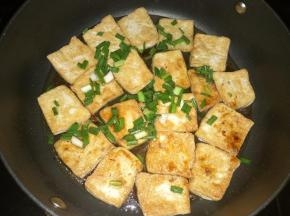 另一面也煎成金黄后放入葱花、生抽、蚝油和适量开火。