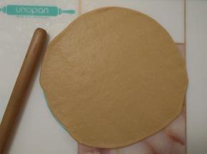 发酵好的面团排气后用擀面杖擀成面片。