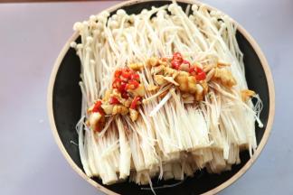 将调好的料汁一半淋在金针菇上