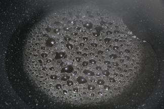 平底锅中倒入半碗水，加入白糖，熬成浓稠的糖汁。