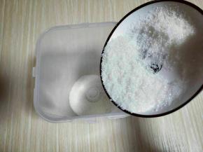 首先将白砂糖倒入酸奶盒中。