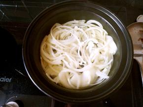 油热之后把圆葱丝倒进锅中，加入少许盐炒软。