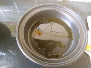 酒精煲的锅体部分放火上，倒入少许植物油。