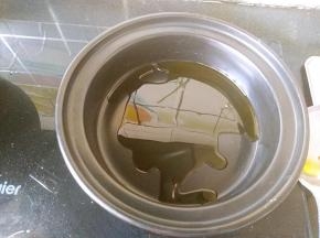 酒精煲的锅体部分放火上，倒入少许植物油。