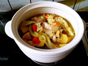 把炒好的菜倒入陶煲王的蒸煲中，加入适量清水和盐。