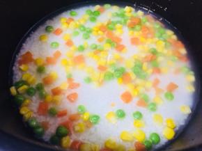 加入蔬菜豆，任何喜欢的品种均可，米饭中的水要比平时煮饭少，浸过米饭一点点即可